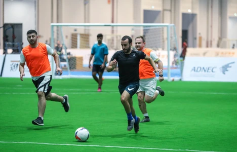 Playing running with ball while playing football at Abu Dhabi Summer Sports